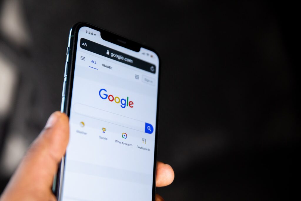 Person holding a phone open to Google. 