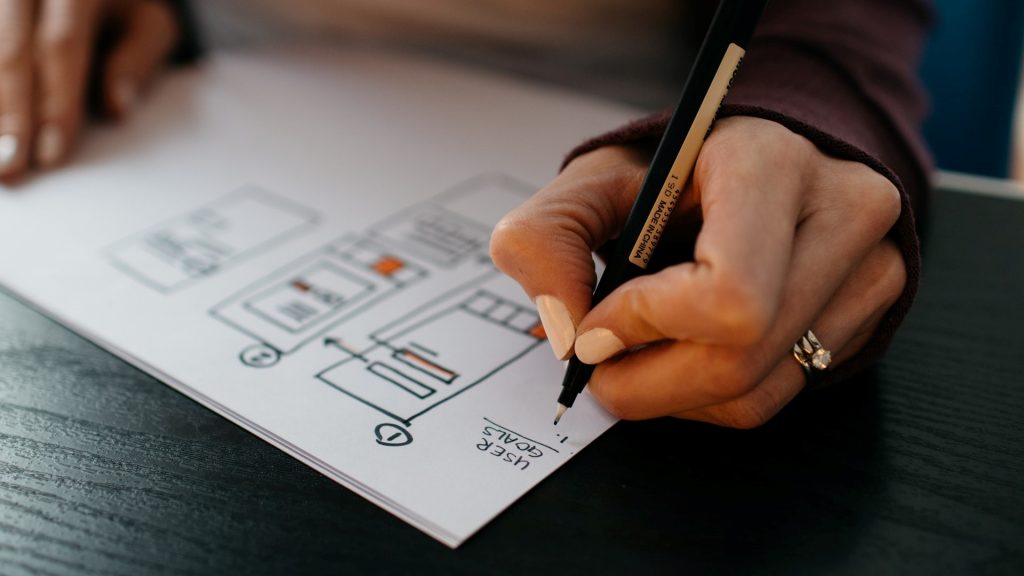 A person sketching a website navigation design